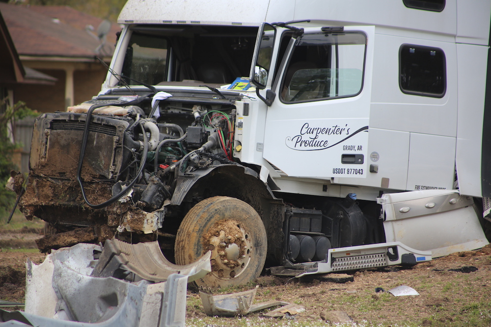 A white truck that has been smashed in to pieces.