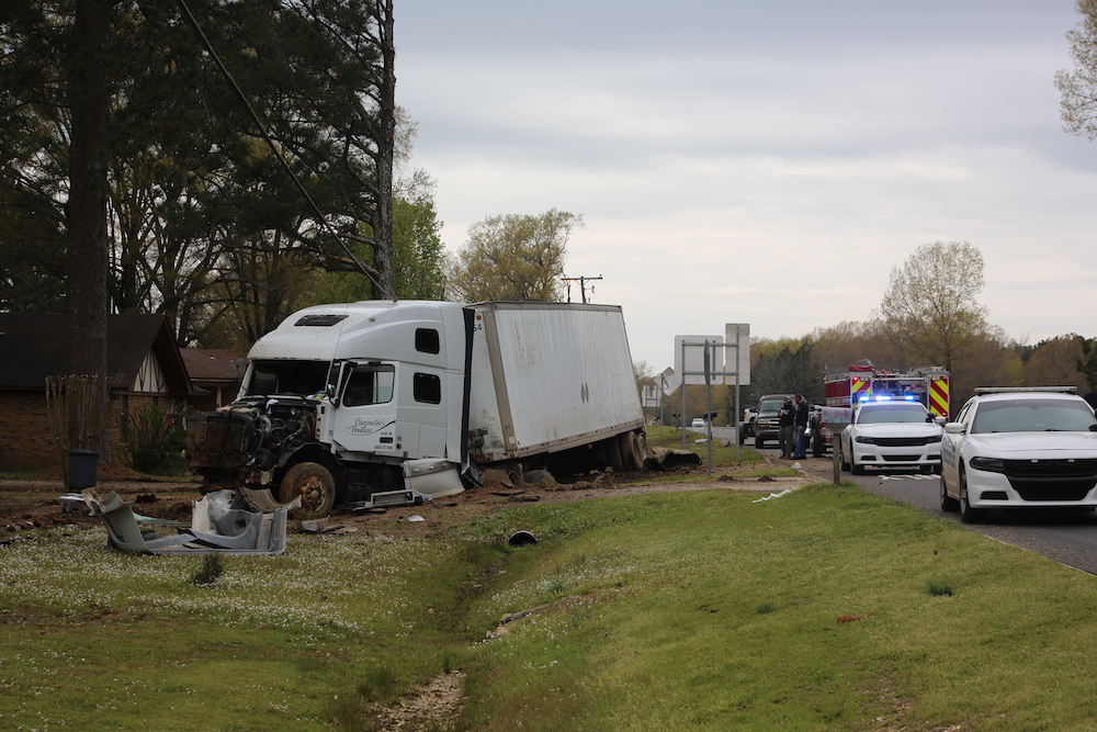 A white truck that has been smashed into by another vehicle.