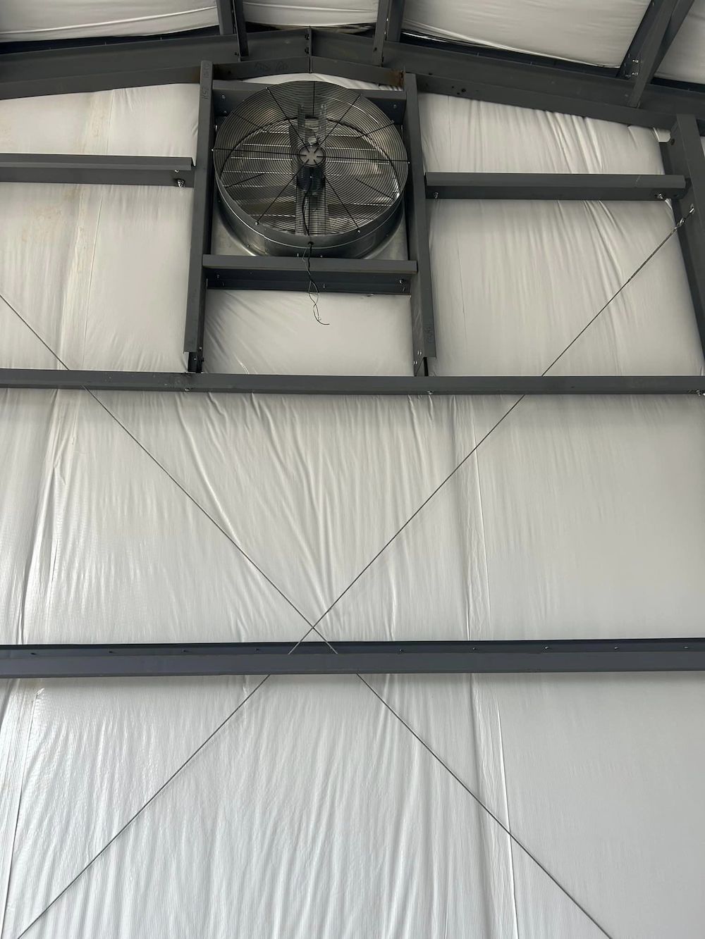 A fan is hanging on the side of a building.