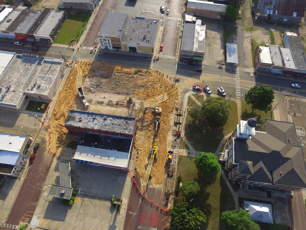 An aerial view of a construction site in the middle of town.