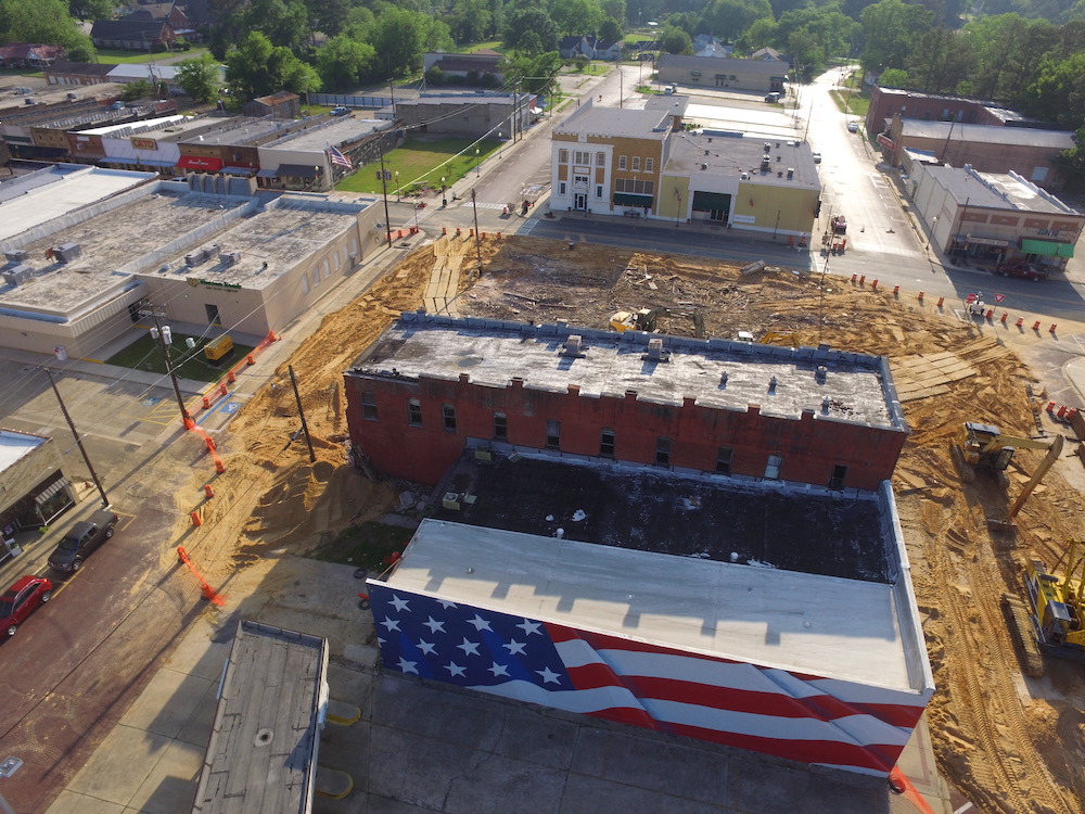 An aerial view of a construction site with buildings and trees.