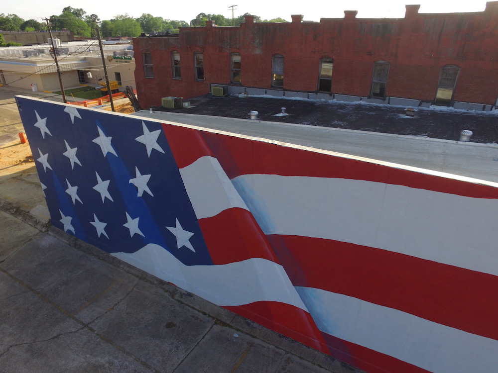 A mural of the american flag painted on the side of a building.