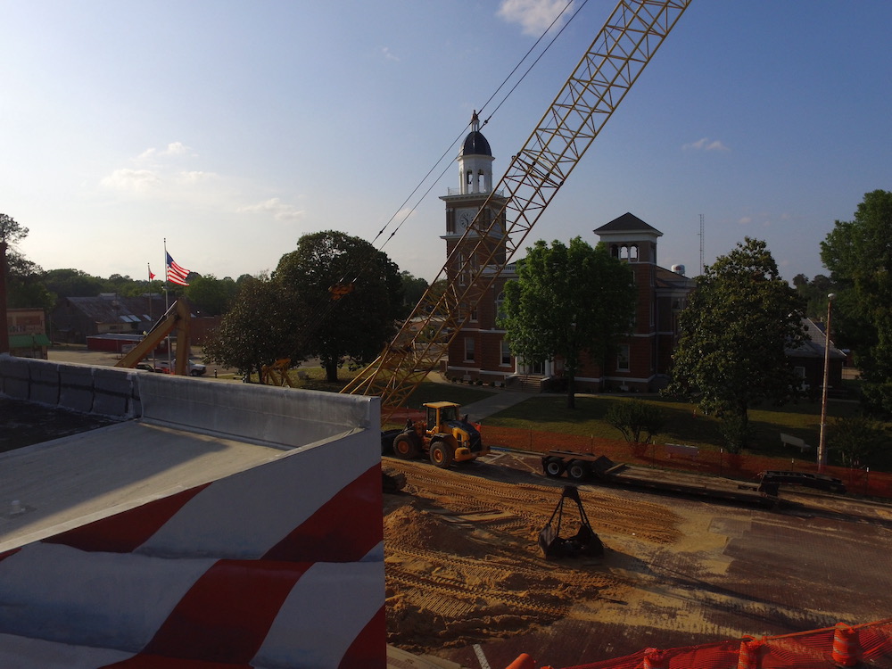 A construction site with a crane and a clock tower.
