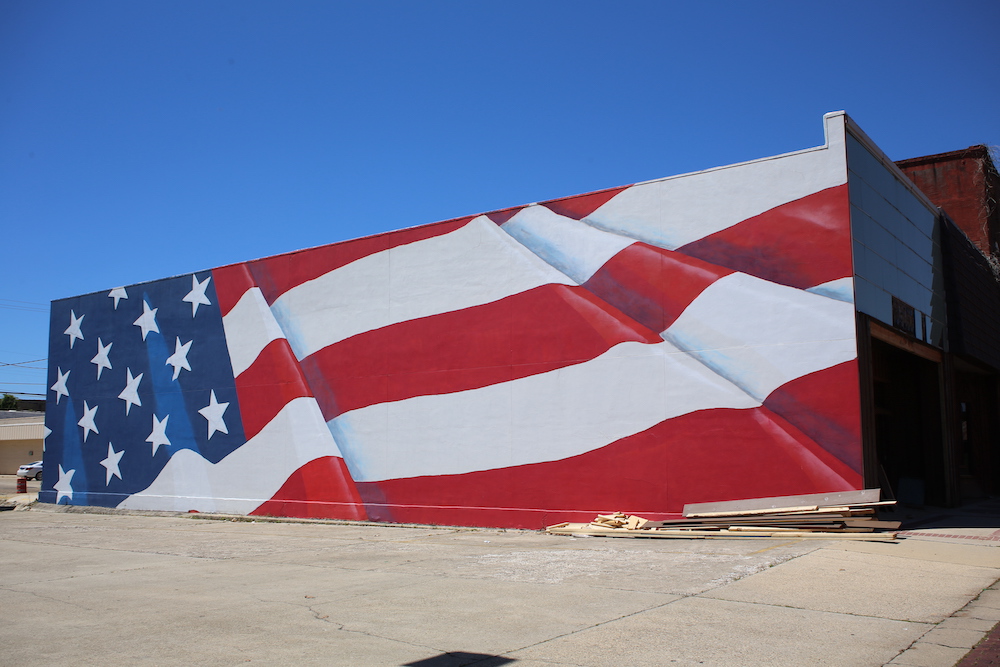A large american flag painted on the side of a building.