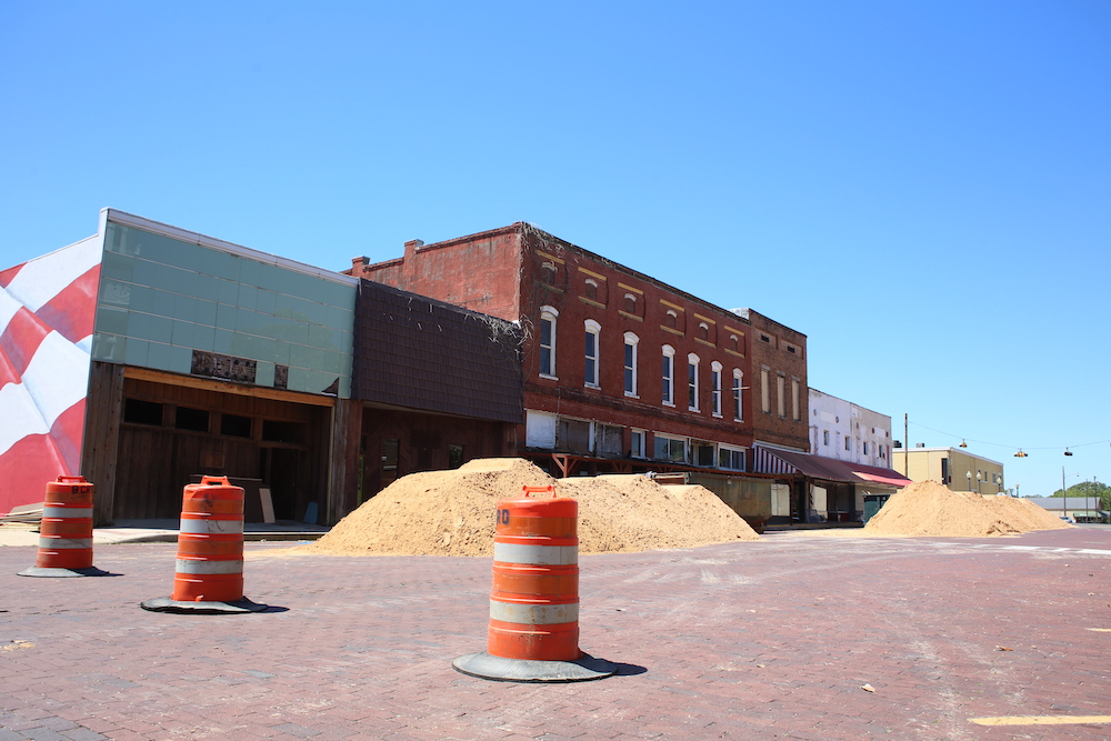 A street with orange and white cones on the side of it.