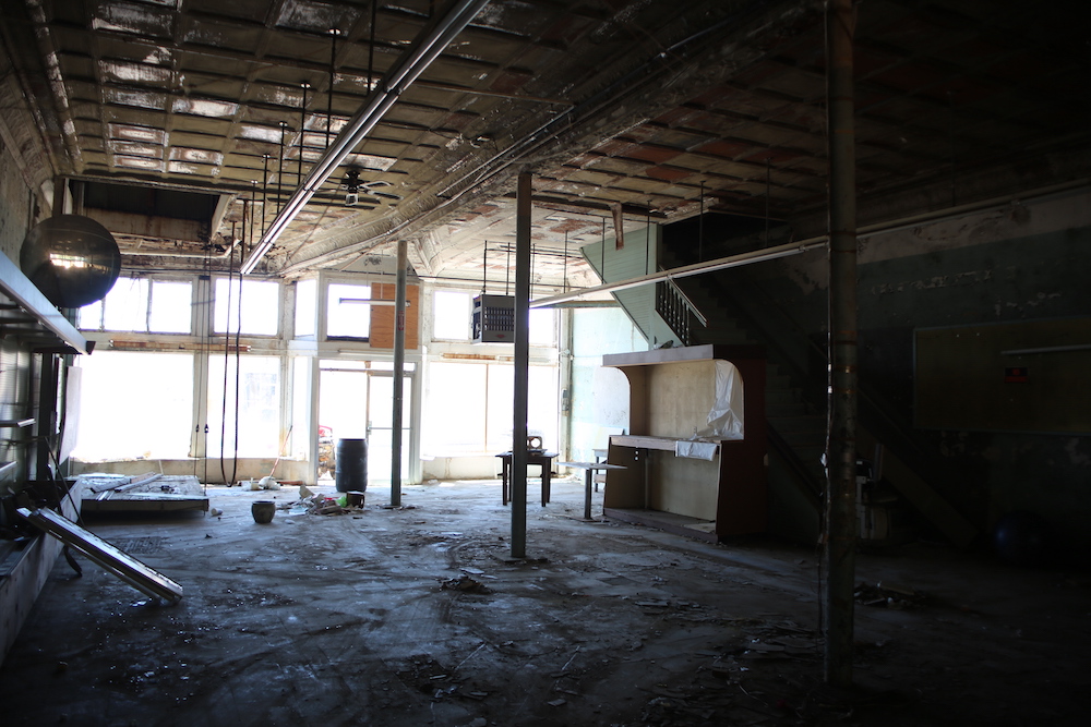 A room with lots of windows and concrete floors.
