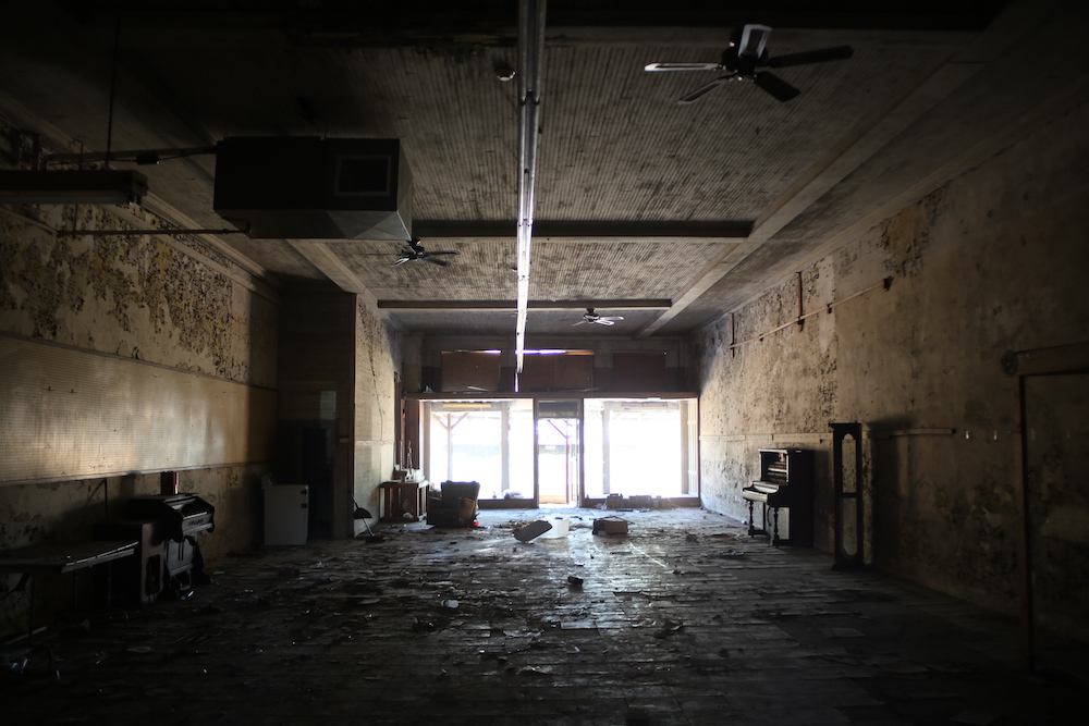 A room with lots of windows and concrete floors.