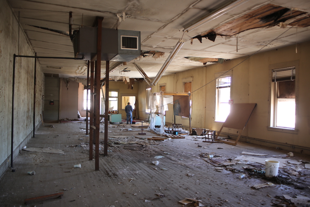 A room that has been demolished and the ceiling is torn off.