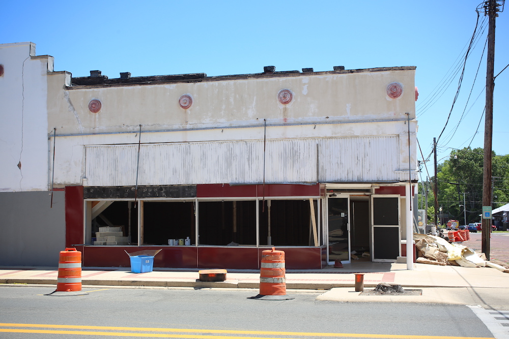 A building that is being demolished on the side of the road.