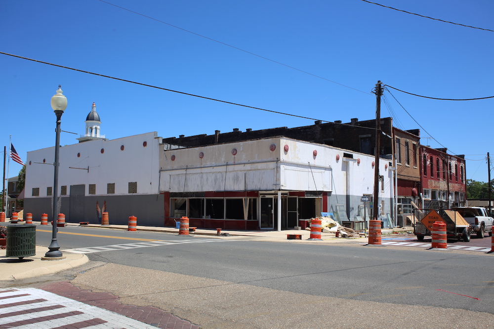 A building that is under construction on the corner of a street.