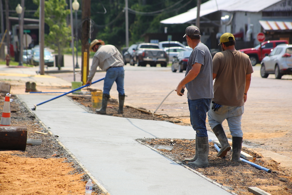 A group of men working on the sidewalk.