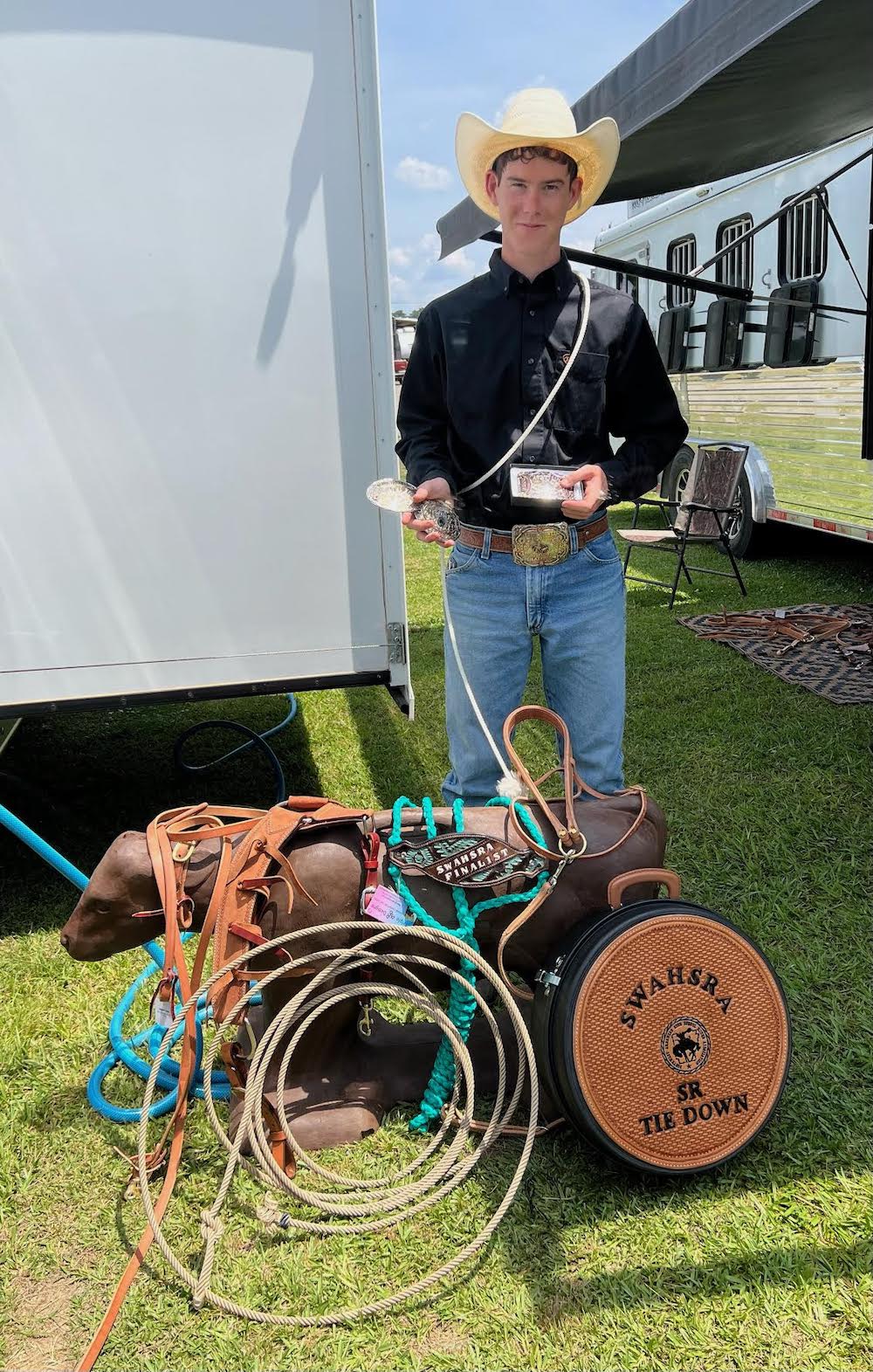 A man standing next to some ropes and a horse.