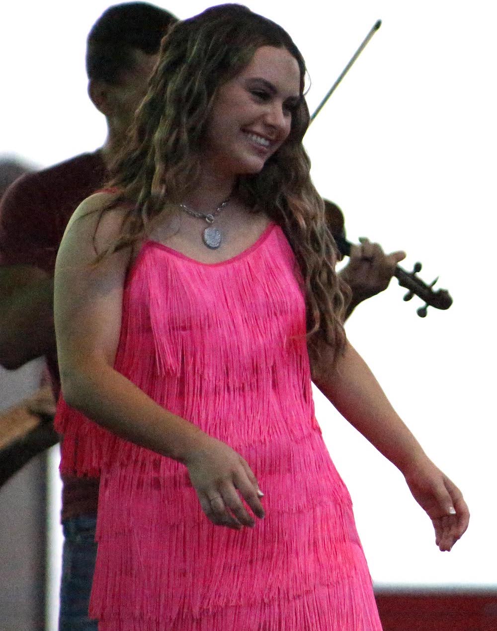 A woman in pink dress holding a violin.