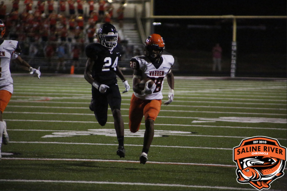 Two football players running on a field