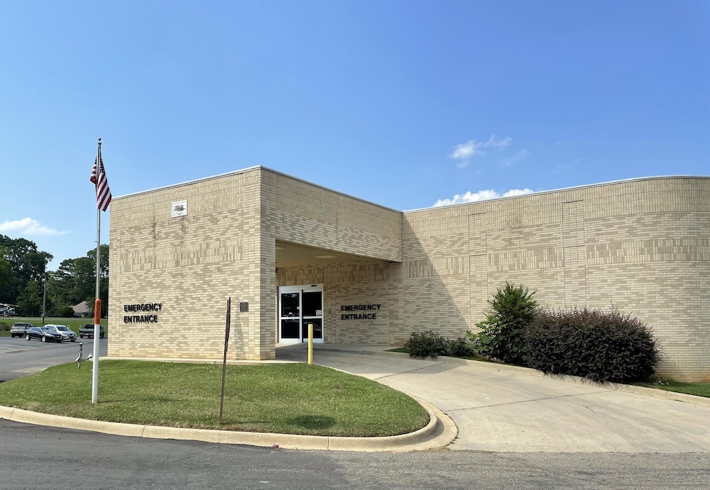 A building with a large entrance and a grassy area.