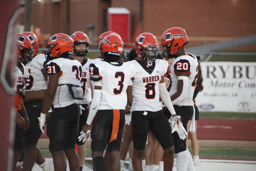 A group of football players standing on top of a field.