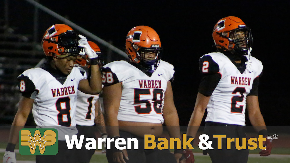 A group of football players standing on top of a field.