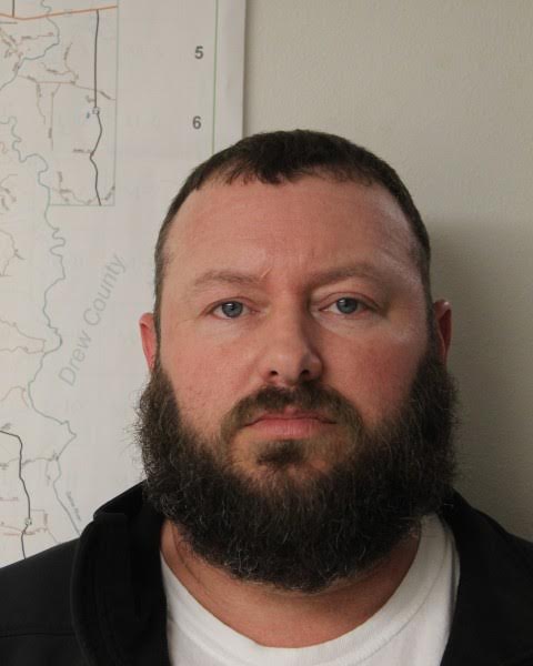 A man with a beard and mustache wearing a jacket.