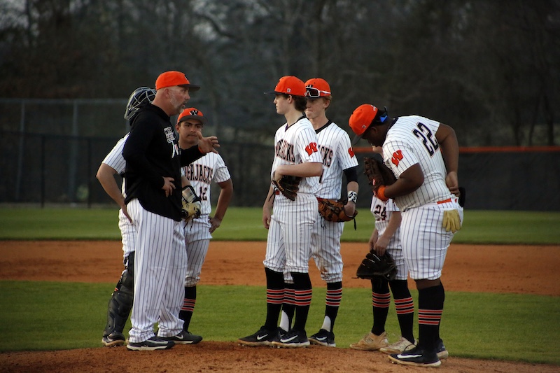 A group of baseball players standing on top of a field.