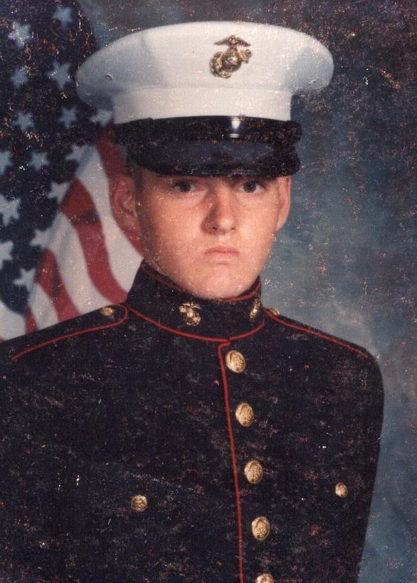 A man in uniform with an american flag behind him.