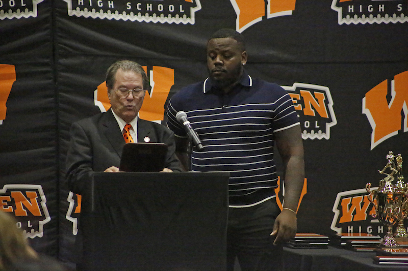 A man standing at the podium with an ipad.