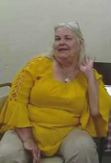 A woman in yellow is sitting on the couch