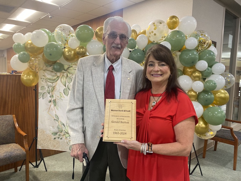 A woman holding an award standing next to a man.