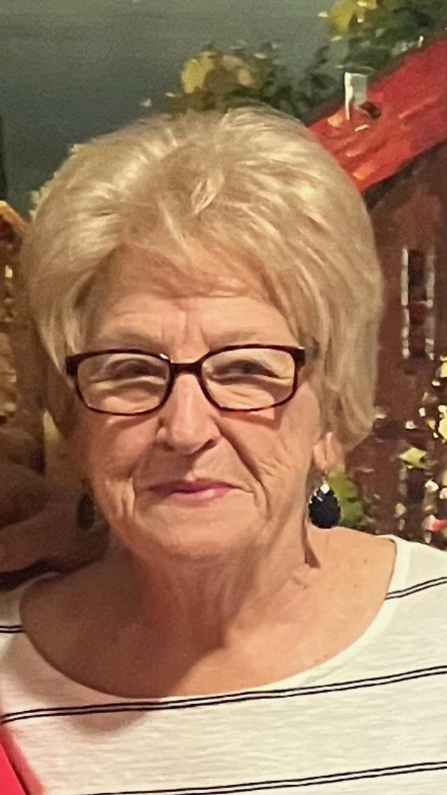 A woman with glasses and blonde hair.