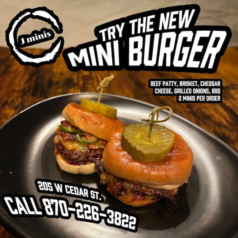 A burger with pickles on top of it.