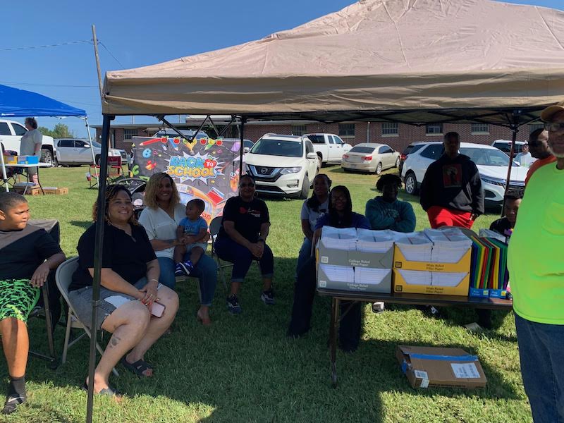 A group of people sitting under a tent.
