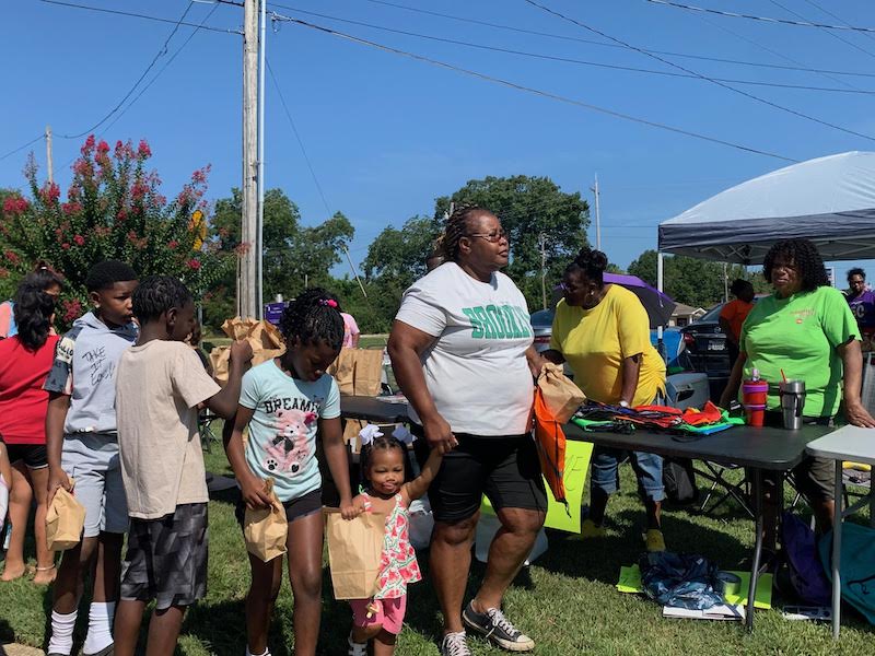 A group of people standing around an outdoor event.