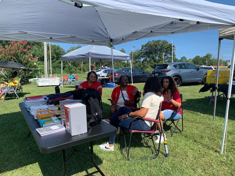 A group of people sitting under a tent.