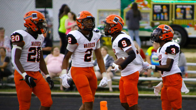 Two football players are talking to each other.