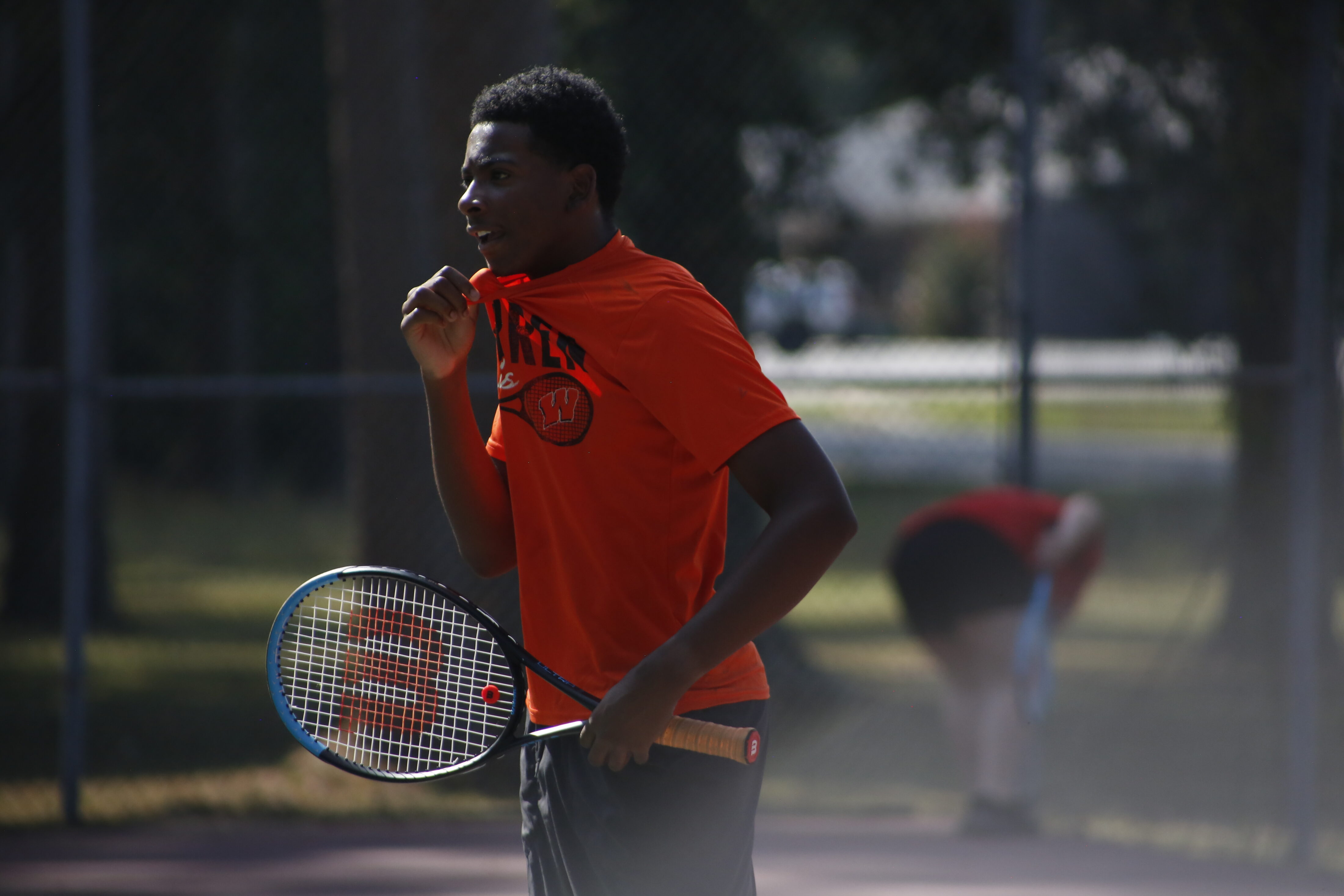 A man holding a tennis racket on the court