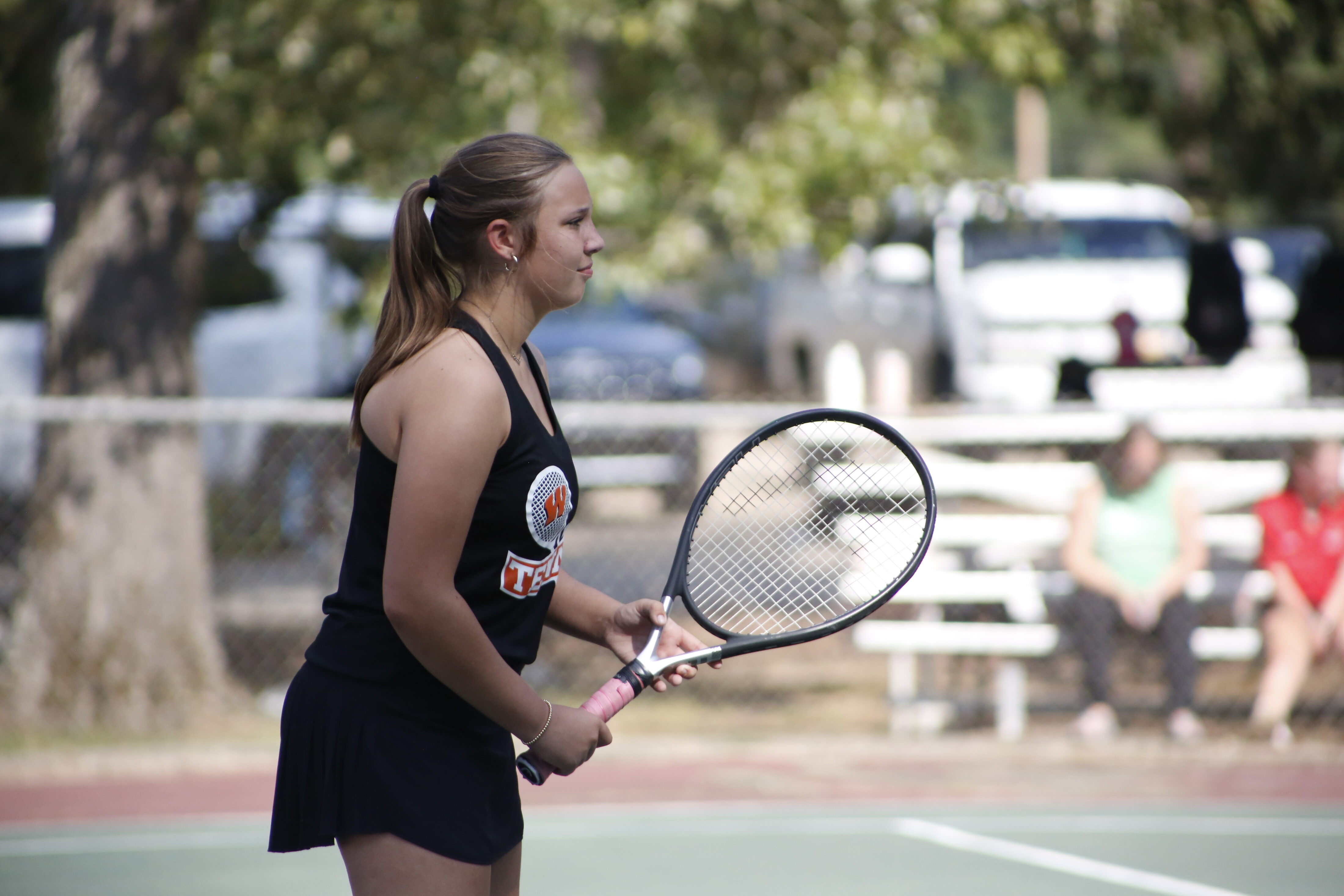 A woman holding a tennis racket on the court