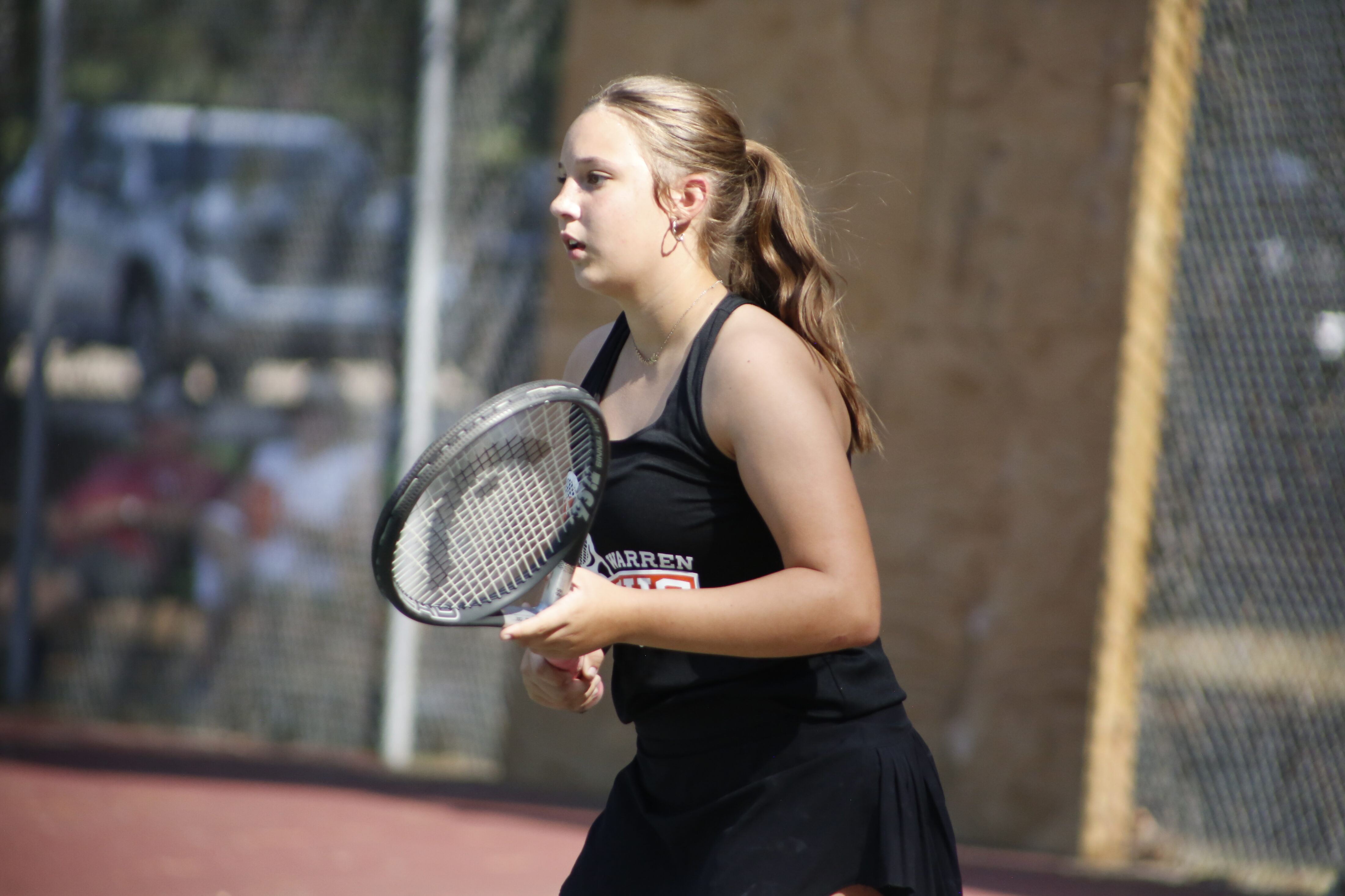 A woman holding a tennis racket on the court