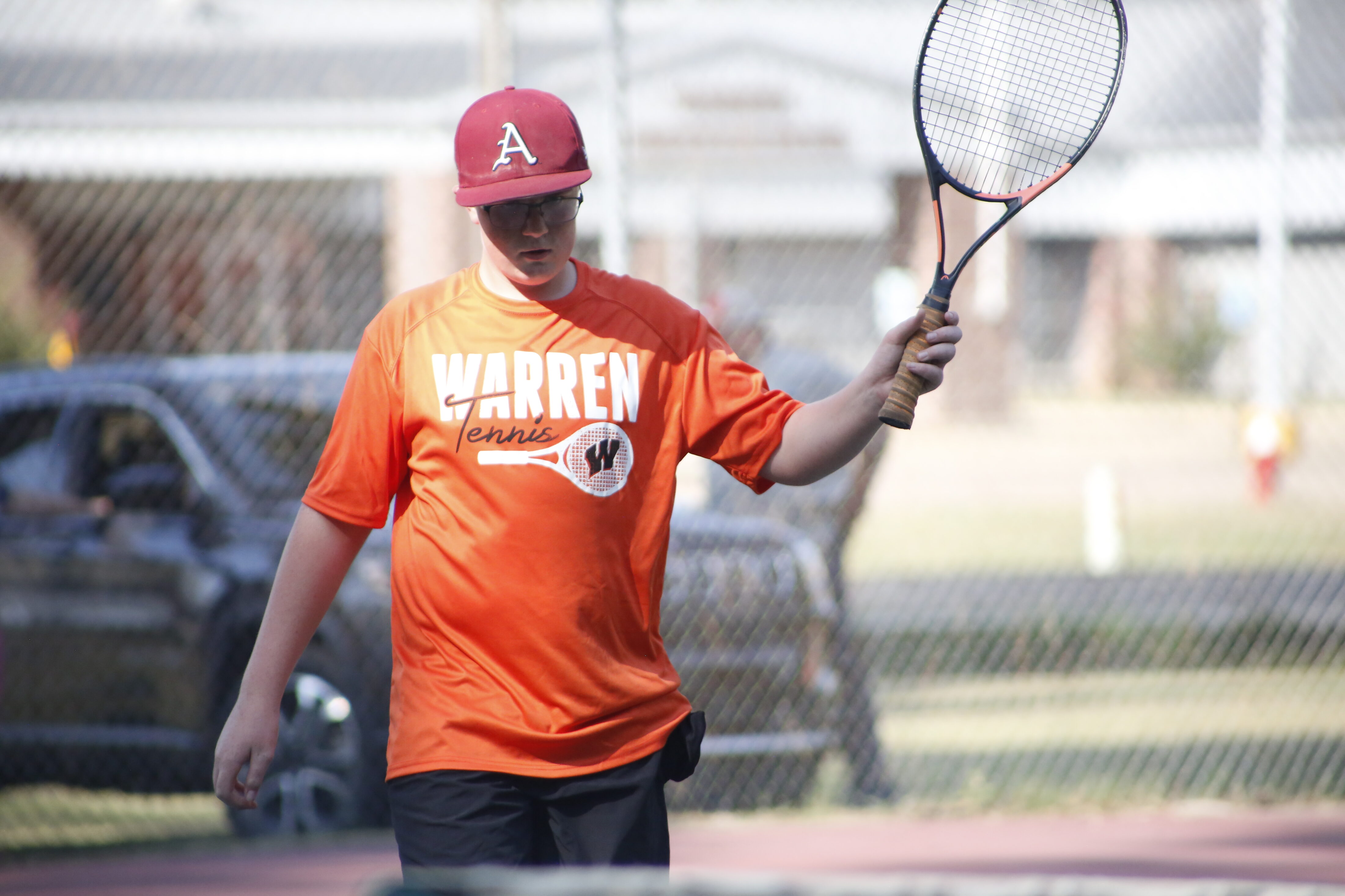 A man holding a tennis racket on top of a court.