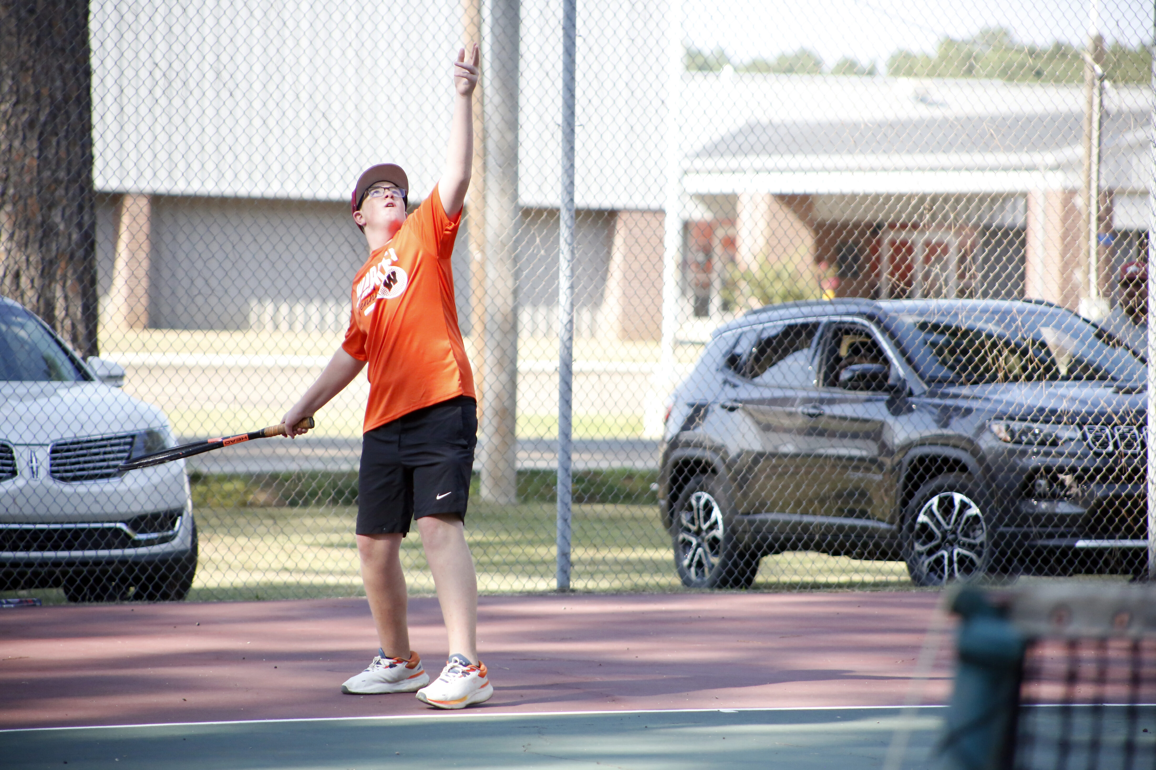 A man holding a tennis racket on top of a court.
