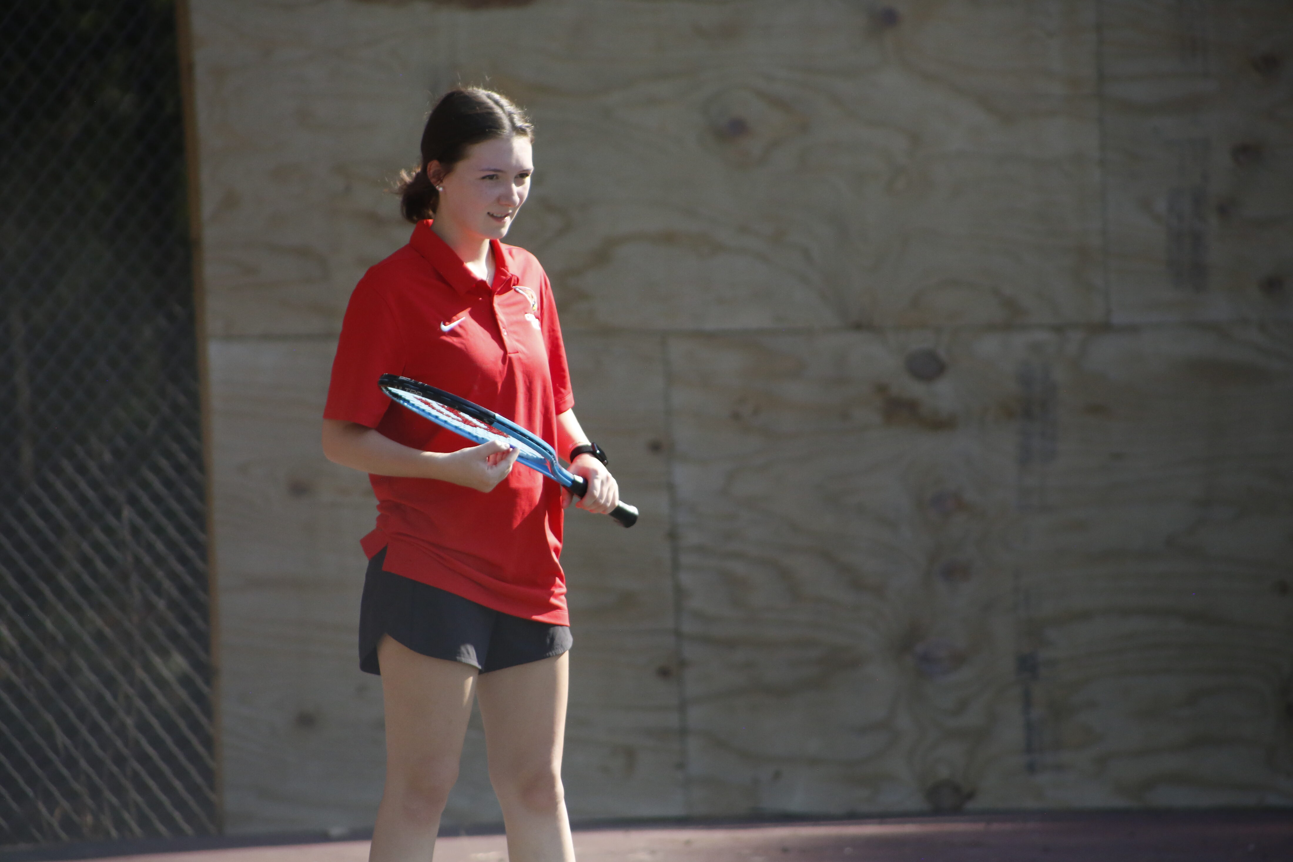 A woman holding a tennis racket in her hand.