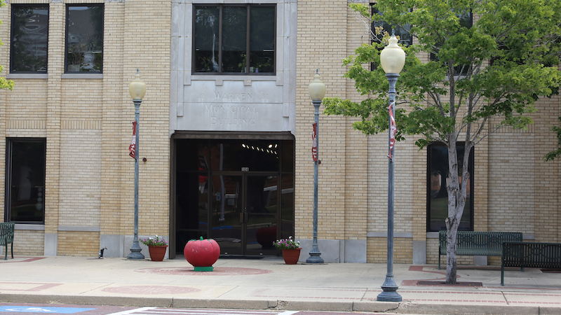 A red chair sitting in front of a building.