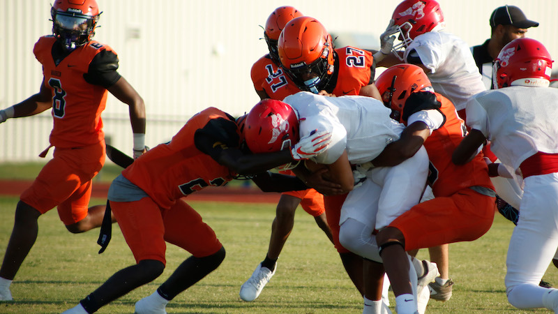 A group of men in orange and white football uniforms.