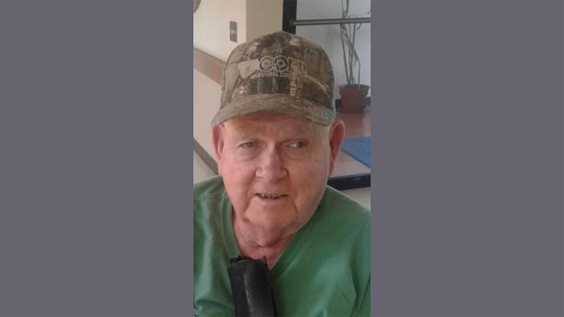 A man wearing a hat and green shirt.