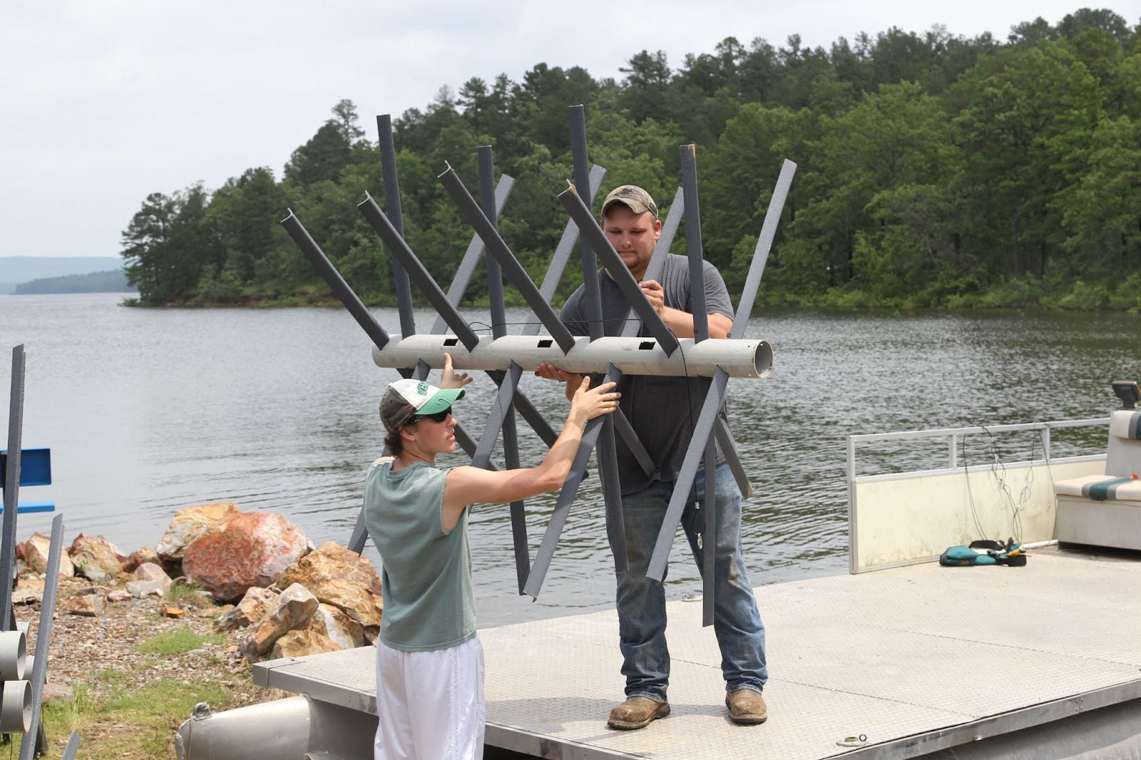 A man and woman holding up a large pole.