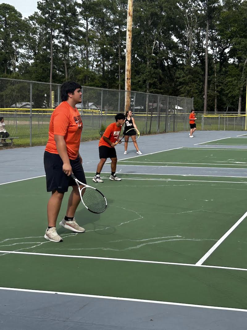 A group of people that are on the tennis court
