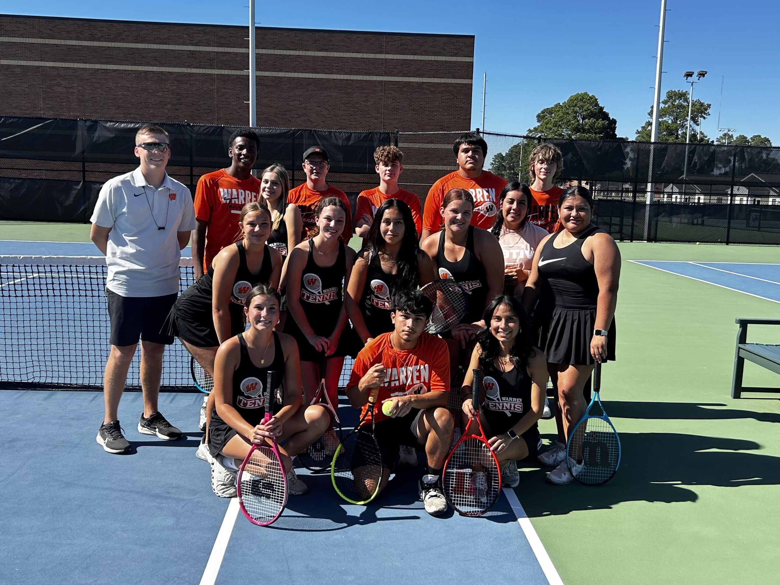A group of people that are on the tennis court