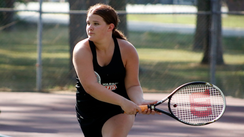 A woman holding a tennis racket on the court