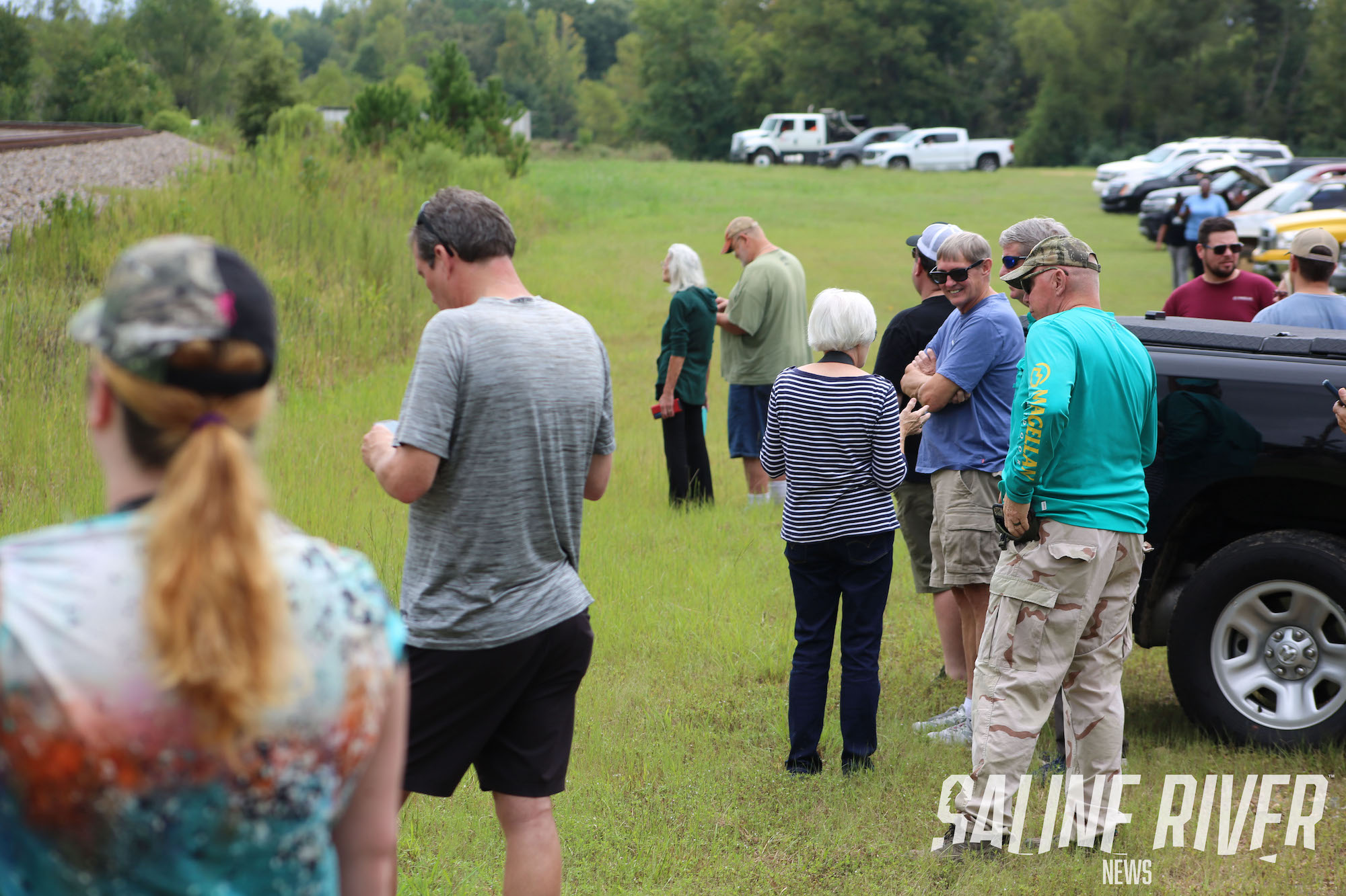 A group of people standing in the grass.