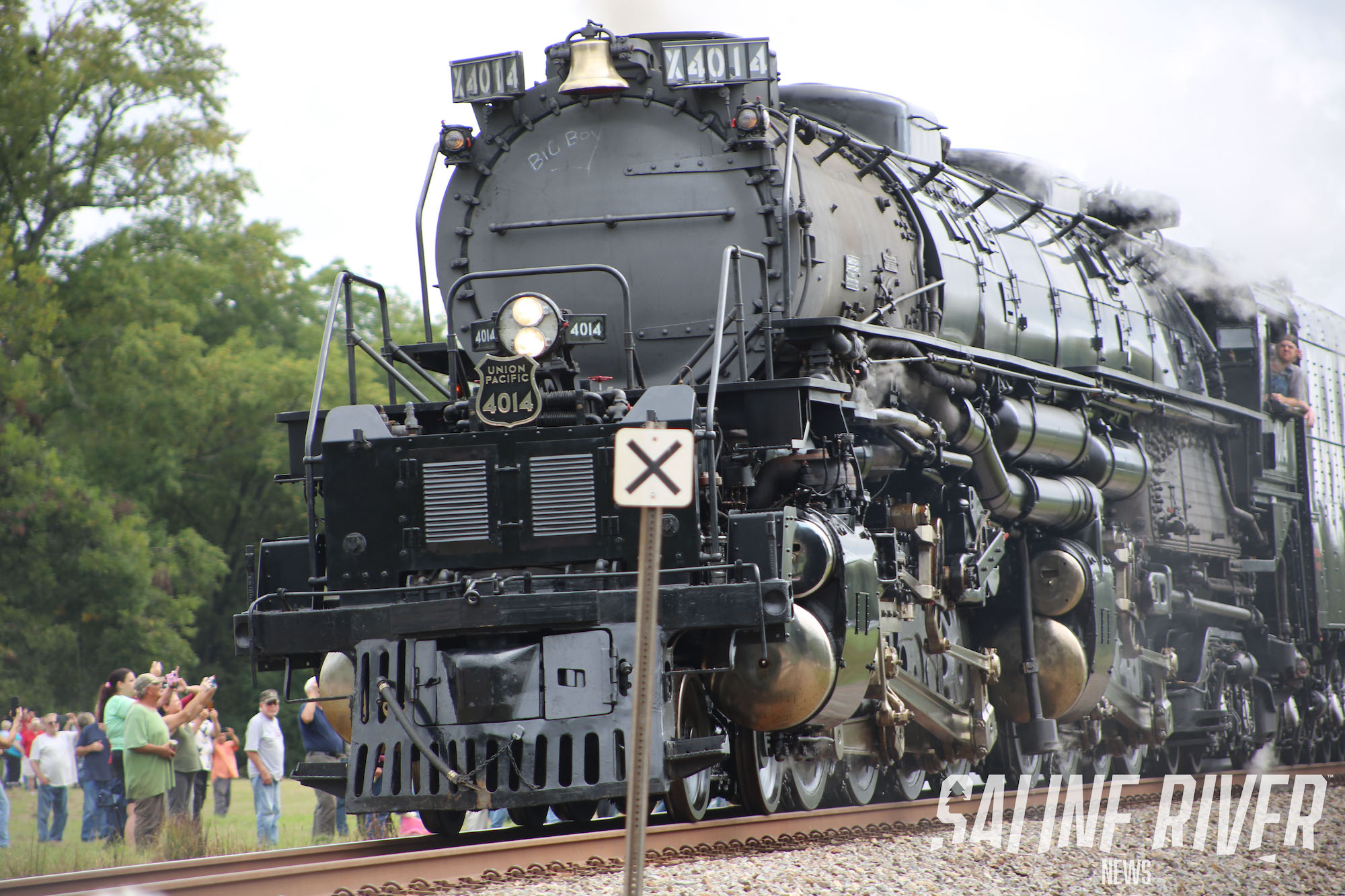 A train is on the tracks with people walking around.