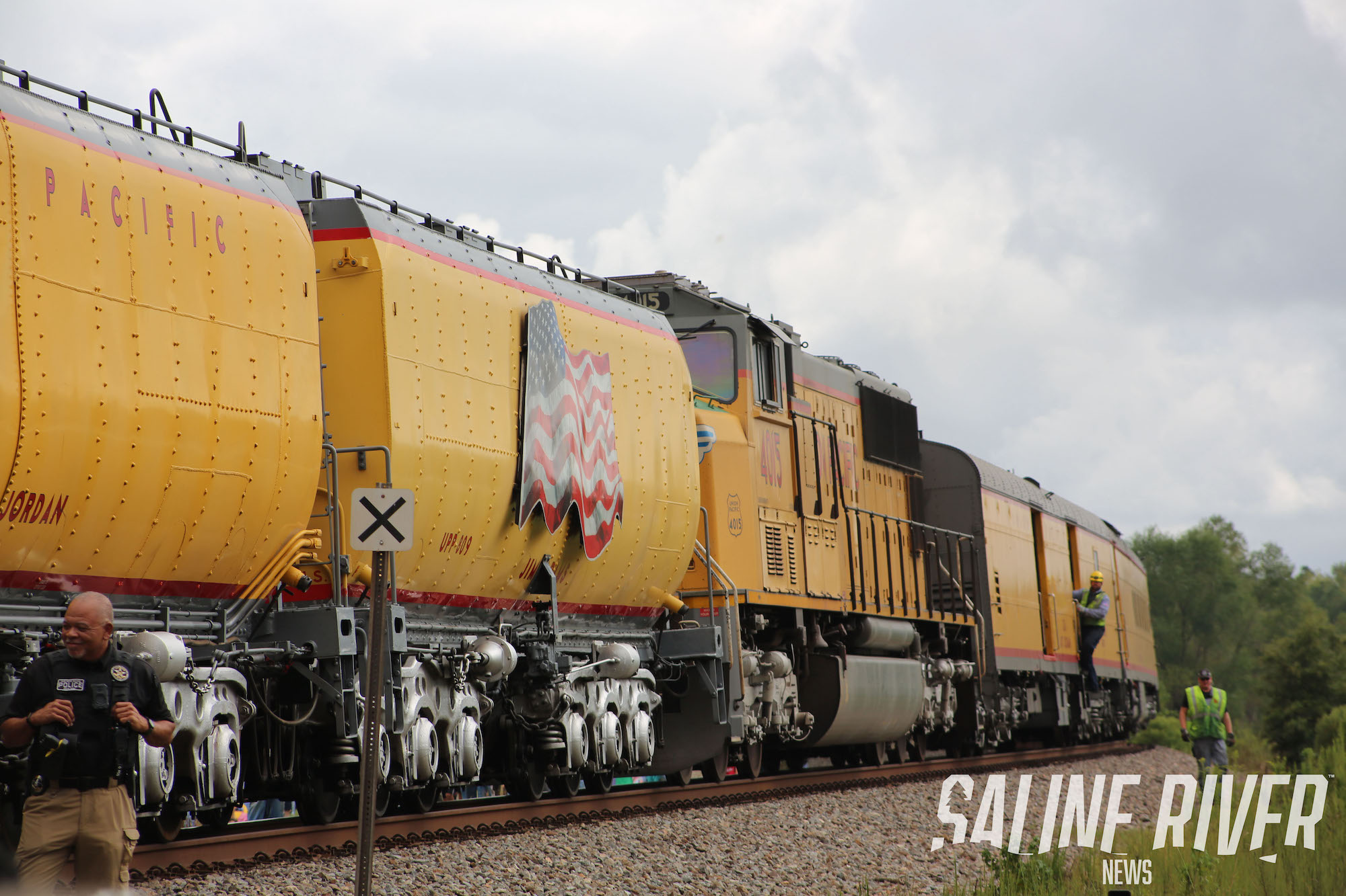 A train is on the tracks near some trees.