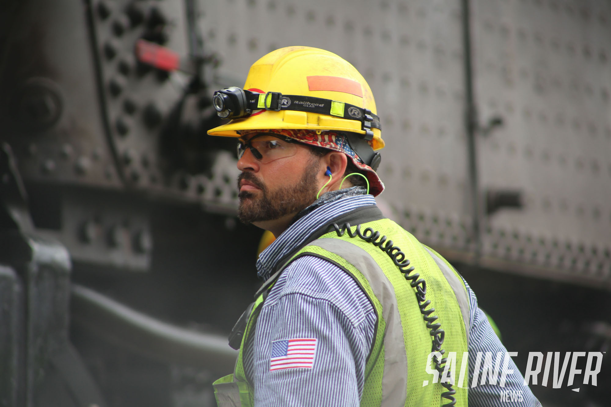 A man in yellow hard hat and reflective vest.